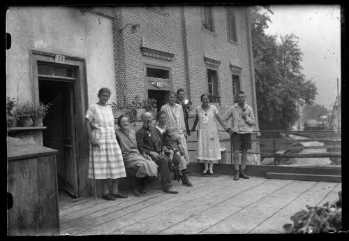 [Aufnahme von Wilhelm Purtscher sowie weiteren Personen vor einem Zweifamilienhaus]