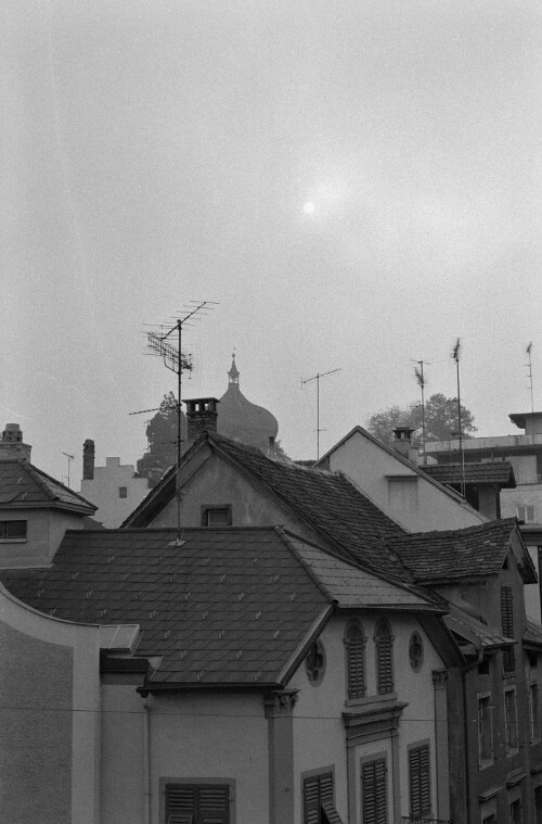 [Bregenz, Hausdächer und Martinsturm im Nebel]