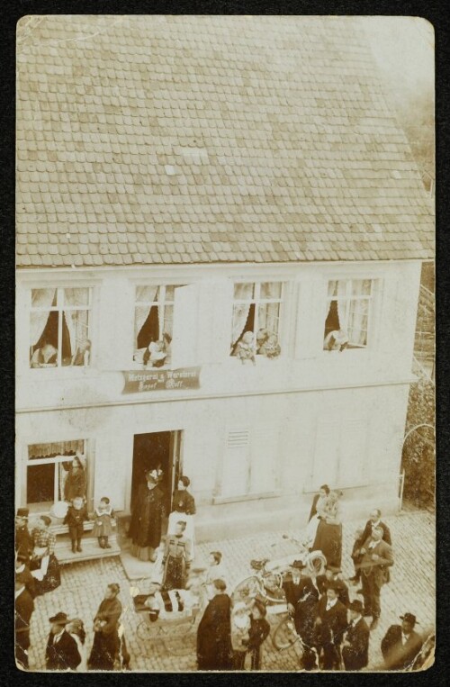 [Umzugsteilnehmer vor der Metzgerei Ruff in der Kirchstraße in Hard]