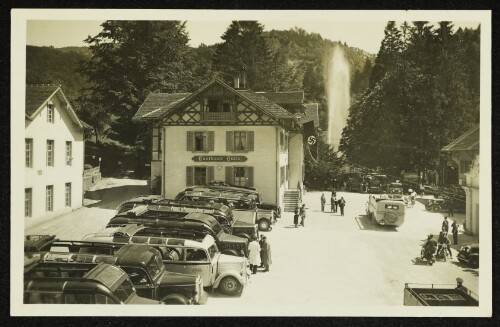 Gasthaus Gütle mit Wasserfontäne und parkenden Autobussen