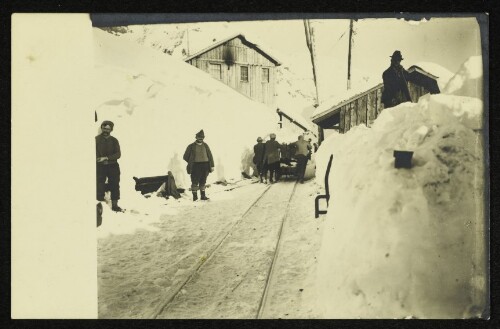 Arbeiter bei einer schneebedeckten Gleisanlage im Gebirge