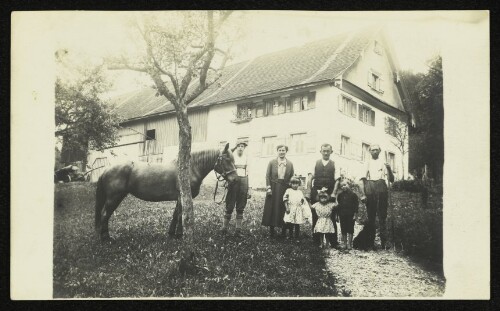 Gruppenbild einer Familie mit Pferd vor einem Bauernhaus