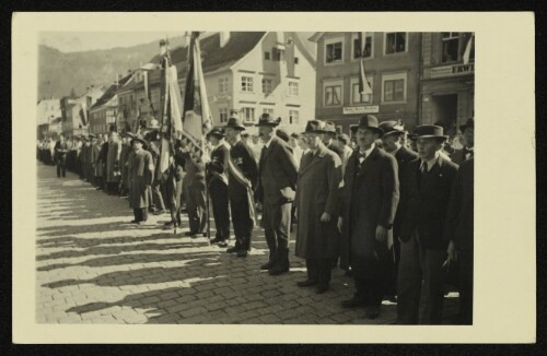 Männergruppe bei einer Aufstellung mit Fahnen am Bregenzer Kornmarkt