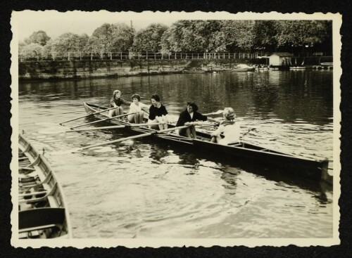 Fünf Frauen in einem Ruderboot auf dem Wasser