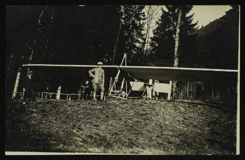 Gleitflugzeug mit Personen vor Waldkulisse