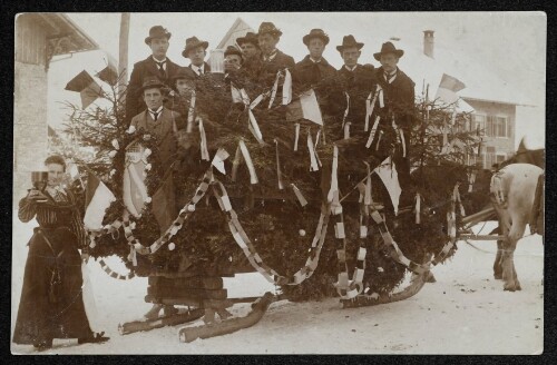 Männergruppe auf einem festlich geschmückten Schlitten im Winter